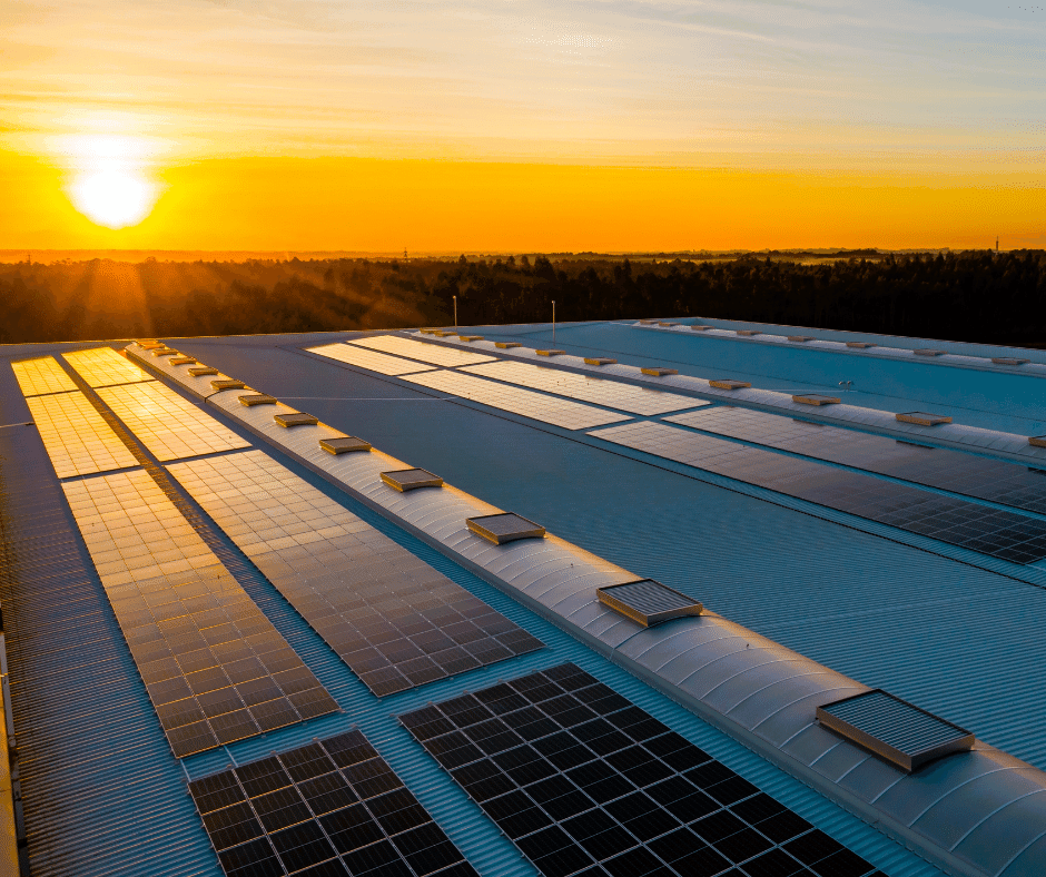 Sun rising on commercial building with solar panels.